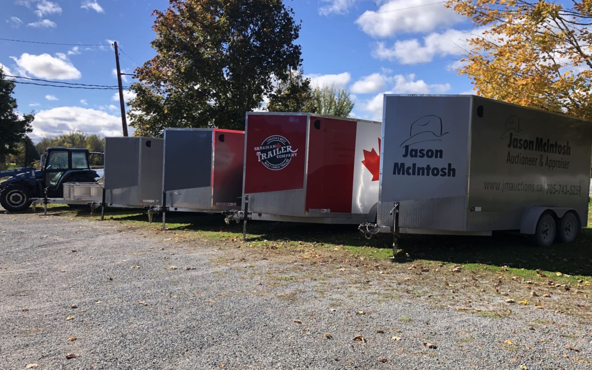A tractor and a row of enclosed trailers, one lettered Jason McIntosh (photograph from the JMAC Auctions website)